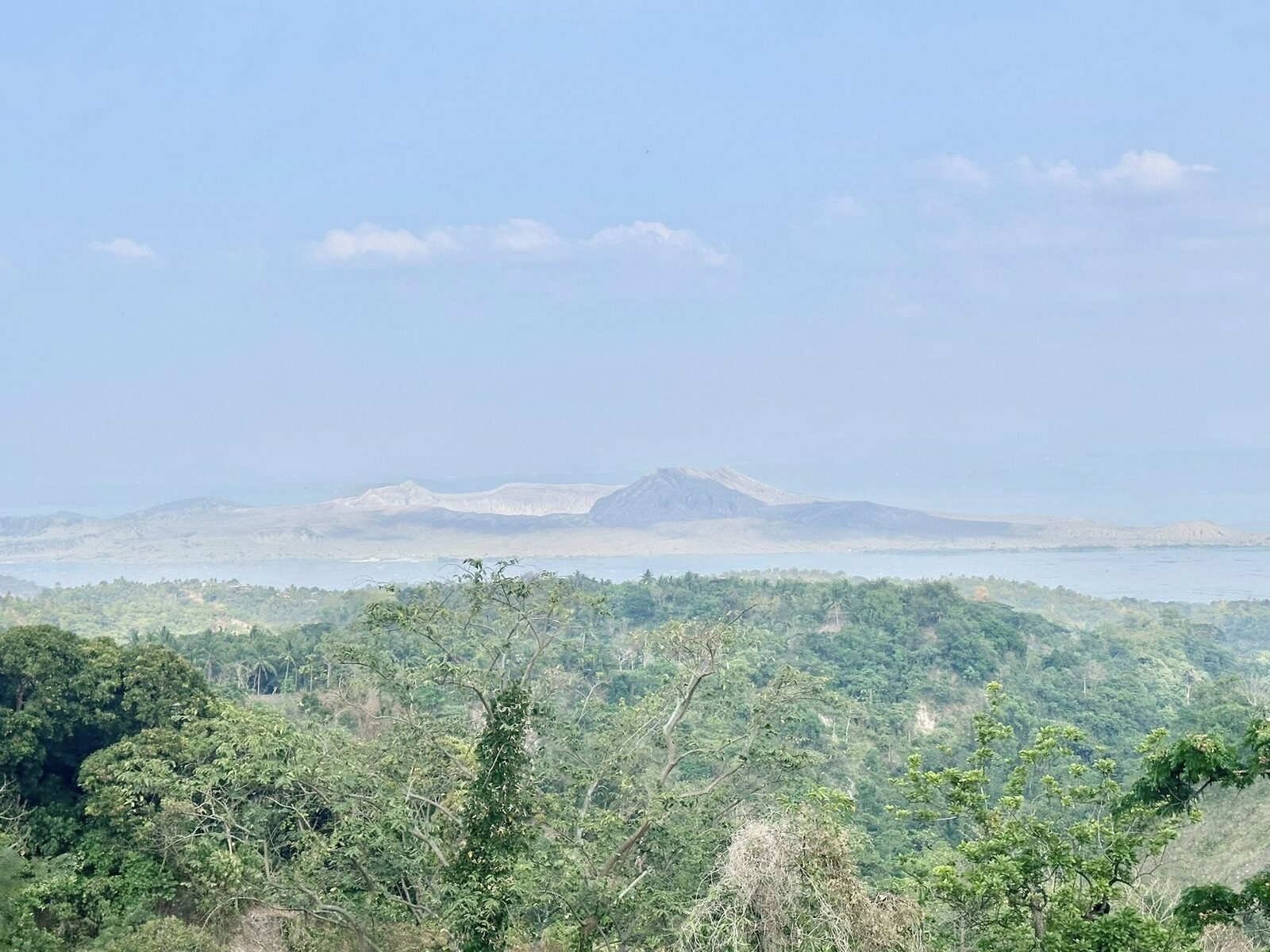 Taal Volcano view from Tagaytay ridge showing the famous volcano-within-a-lake crater landscape with lush green jungle in the foreground