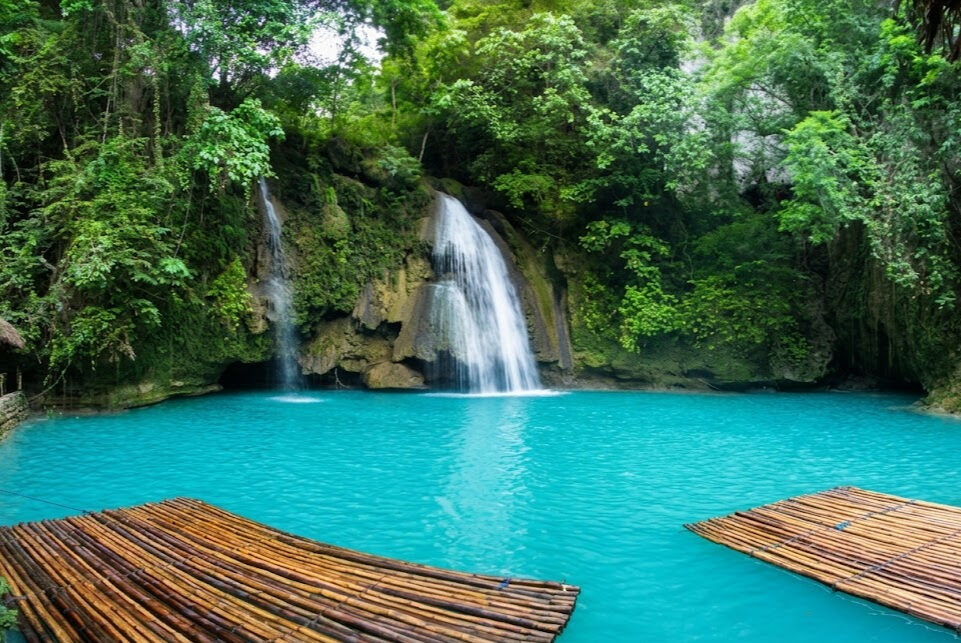 Kawasan Falls Cebu turquoise blue pool with bamboo rafts surrounded by tropical jungle in Badian