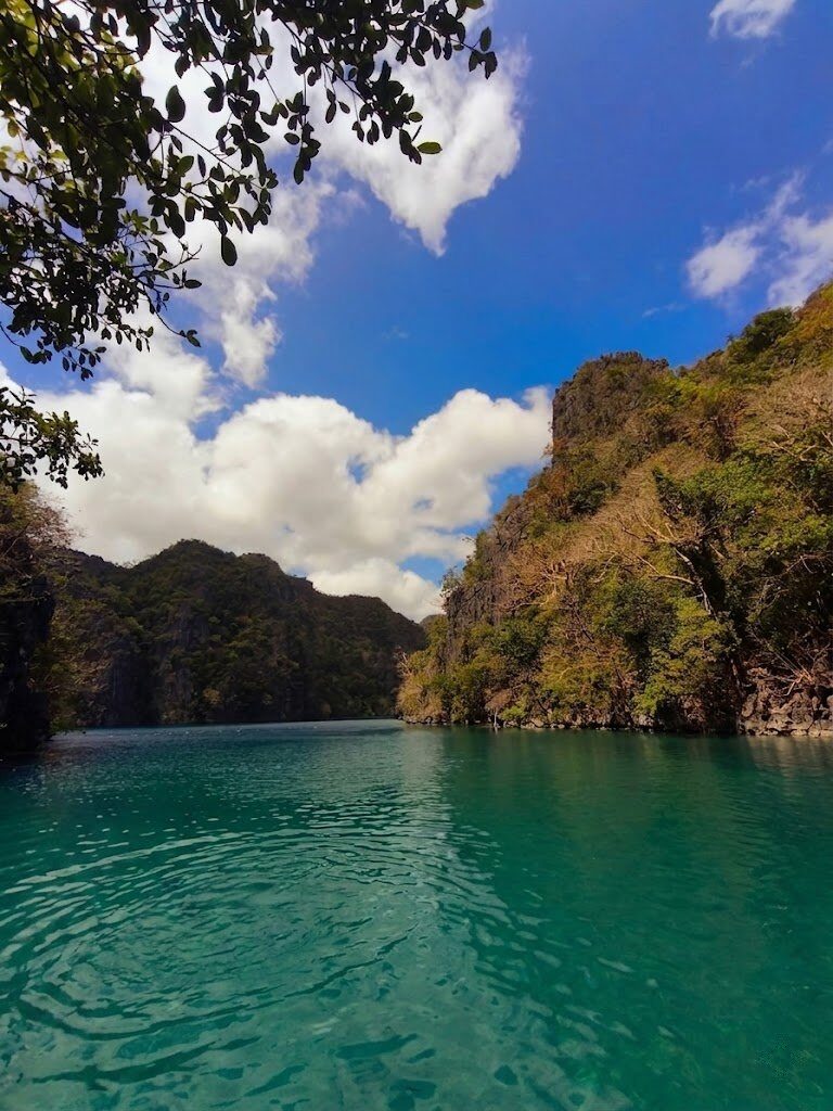 Kayangan Lake Coron emerald green water surrounded by towering limestone karst cliffs in Palawan