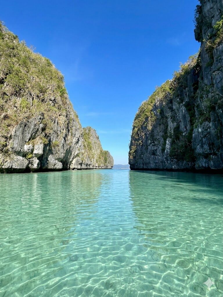 El Nido Big Lagoon clear turquoise water between towering limestone karst cliffs in Palawan Philippines