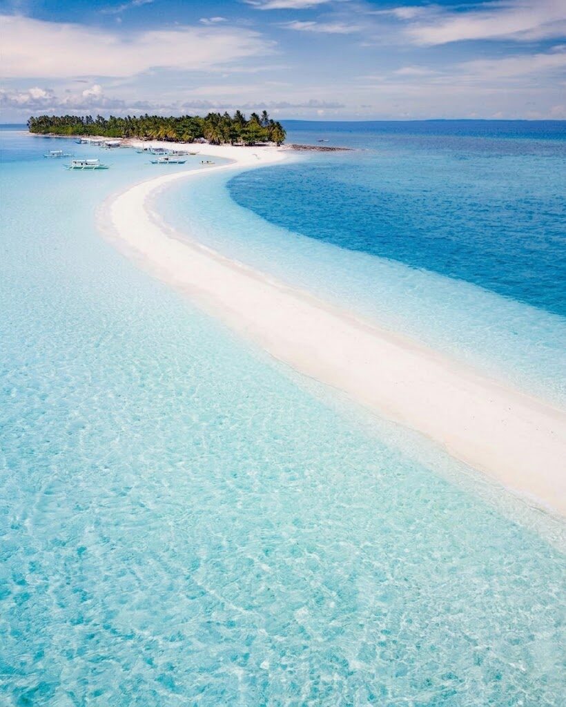 Aerial view of Kalanggaman Island Leyte stunning long curved white sand sandbar extending into crystal clear turquoise water with palm-covered island